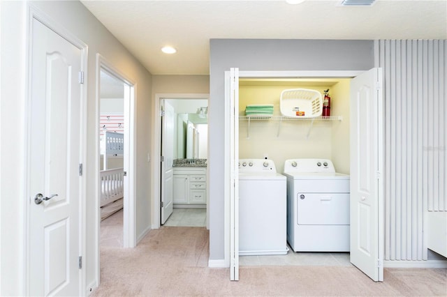 washroom with separate washer and dryer and light colored carpet