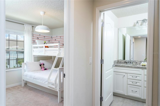 tiled bedroom featuring a textured ceiling and sink