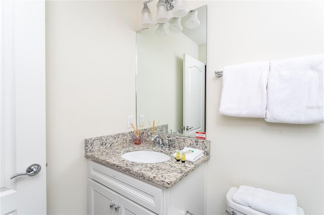 bathroom with toilet and vanity with extensive cabinet space