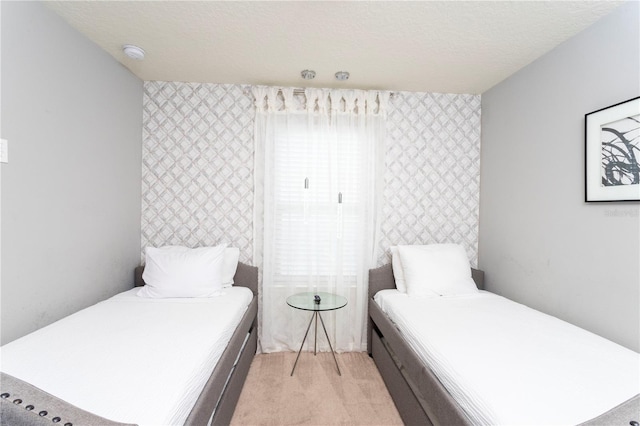 bedroom featuring a textured ceiling and light colored carpet