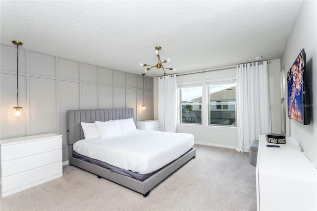 bedroom with a textured ceiling, a chandelier, and light colored carpet