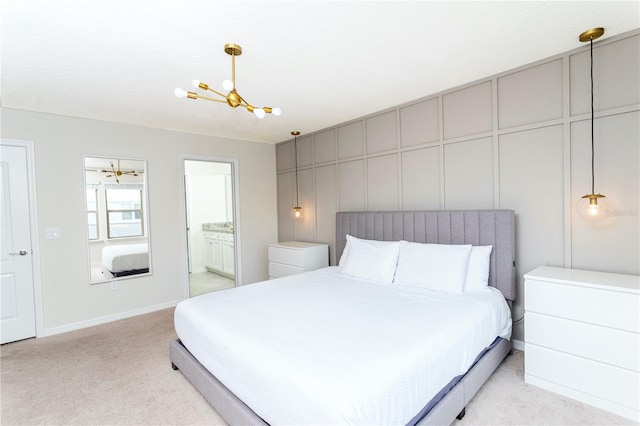 bedroom with connected bathroom, a chandelier, and light colored carpet