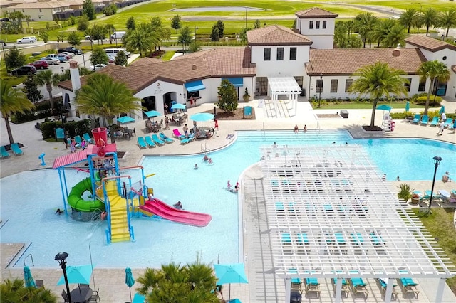 view of swimming pool with a patio area and a water slide