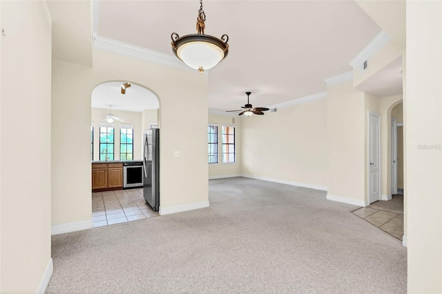 unfurnished living room with light carpet, ceiling fan, and ornamental molding