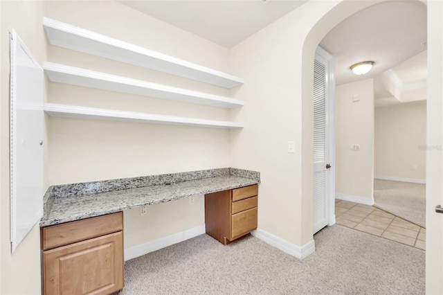 unfurnished office featuring light carpet and built in desk