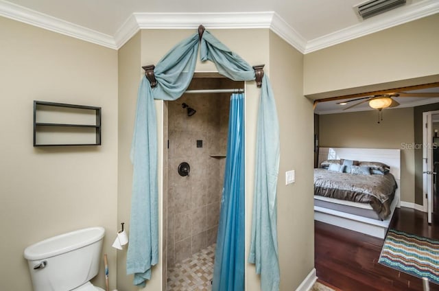 bathroom with ceiling fan, toilet, a shower with shower curtain, hardwood / wood-style flooring, and ornamental molding