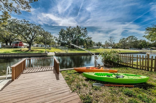 view of dock featuring a water view and a yard