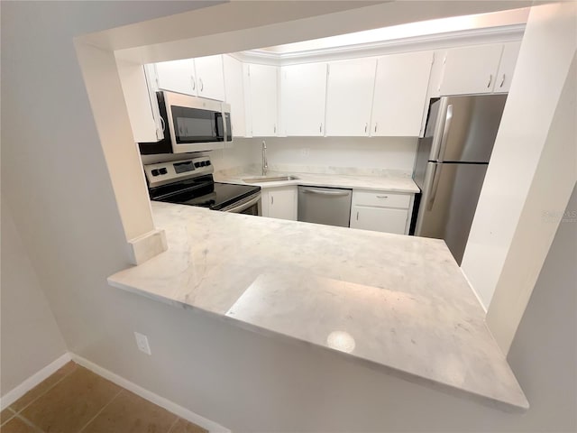 kitchen with sink, white cabinets, stainless steel appliances, and tile patterned flooring