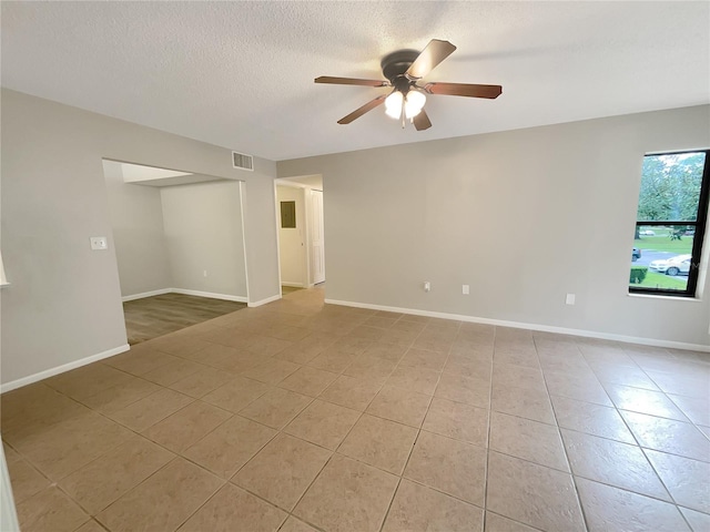 tiled spare room featuring ceiling fan and a textured ceiling