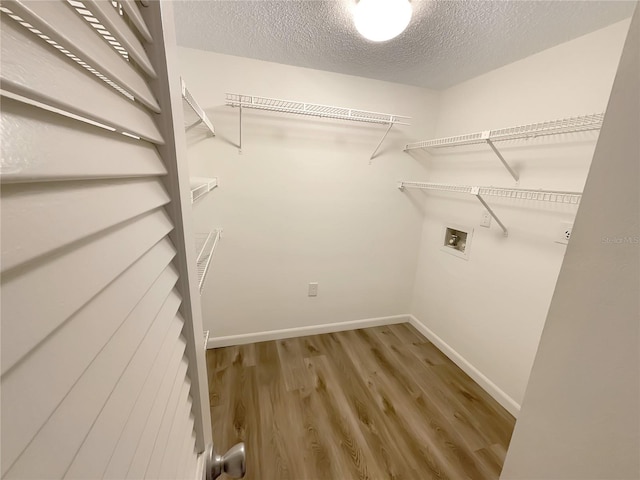 clothes washing area featuring hookup for a washing machine, hardwood / wood-style floors, and a textured ceiling