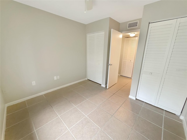 unfurnished bedroom featuring a closet, tile patterned floors, and ceiling fan