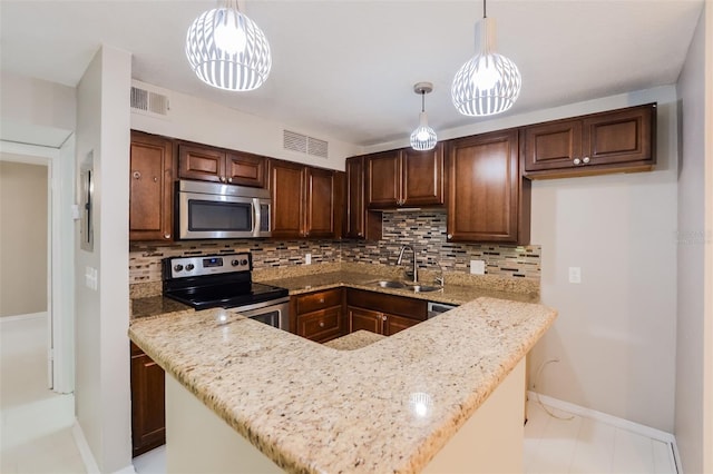 kitchen featuring kitchen peninsula, appliances with stainless steel finishes, hanging light fixtures, and sink