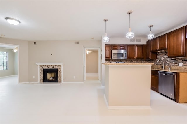 kitchen with tasteful backsplash, pendant lighting, stainless steel appliances, and ceiling fan