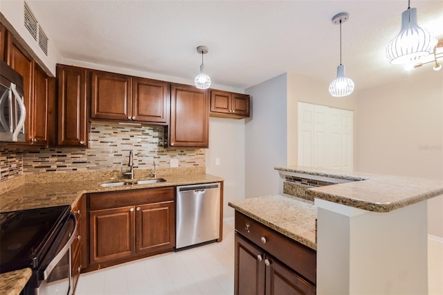 kitchen with pendant lighting, backsplash, sink, appliances with stainless steel finishes, and light stone counters