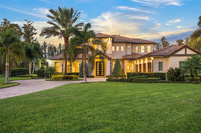 6109 Orta Ct, Windermere, FL 34786 - mediterranean / spanish house featuring french doors, curved driveway, a front lawn, and stucco siding
