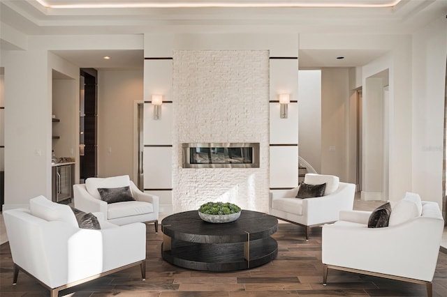 living room with a stone fireplace and dark hardwood / wood-style flooring