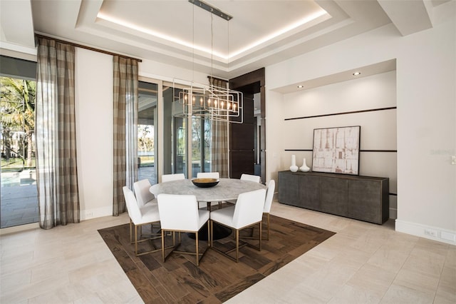 dining area with a notable chandelier, a healthy amount of sunlight, and a tray ceiling