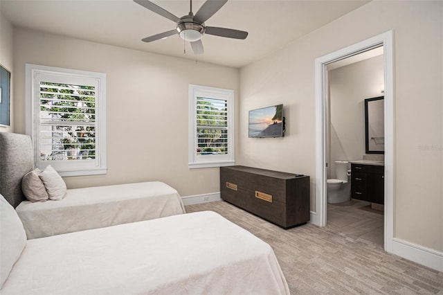 carpeted bedroom featuring ensuite bathroom and ceiling fan