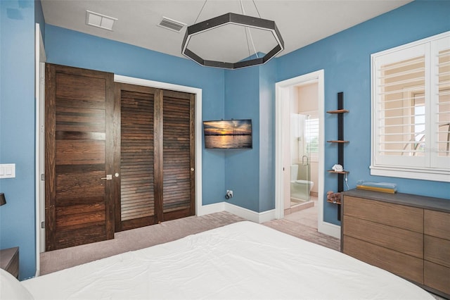 bedroom featuring connected bathroom, light hardwood / wood-style floors, and a closet