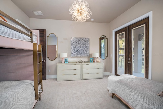 carpeted bedroom featuring french doors, access to exterior, and a chandelier