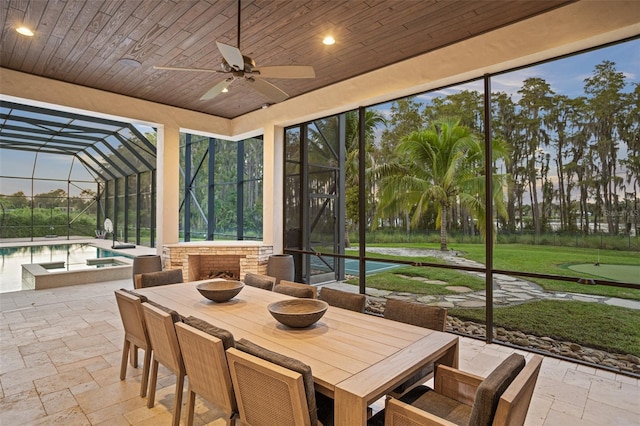 sunroom featuring wood ceiling, vaulted ceiling, and ceiling fan