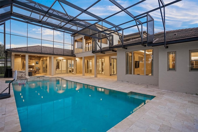 view of swimming pool featuring a patio and a lanai