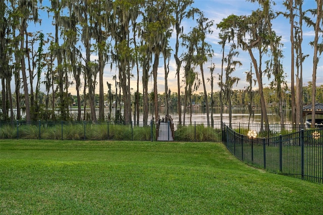 view of property's community with a water view and a lawn