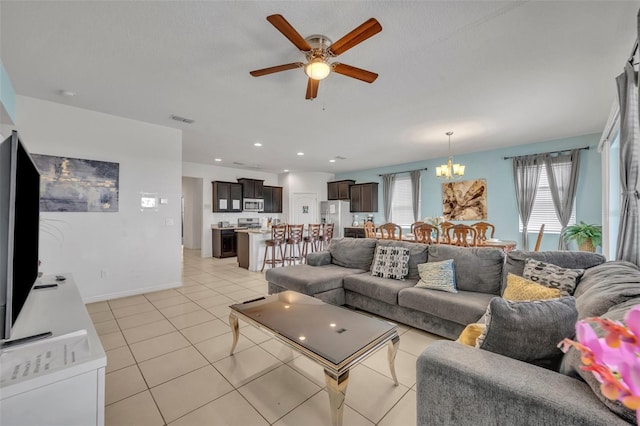 living room featuring ceiling fan with notable chandelier and light tile patterned floors