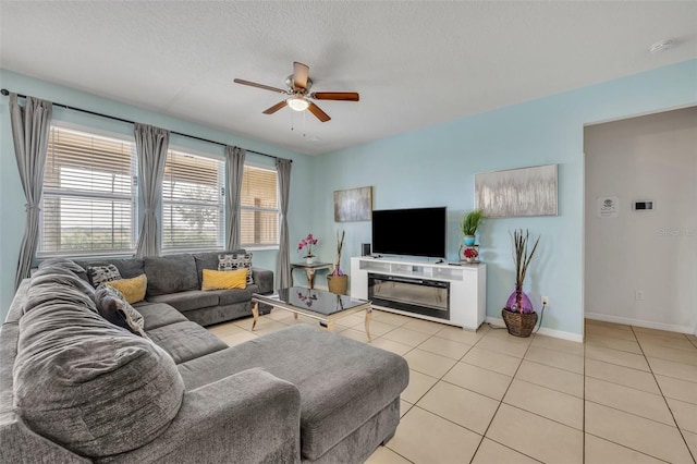 living room with ceiling fan, light tile patterned floors, and a textured ceiling