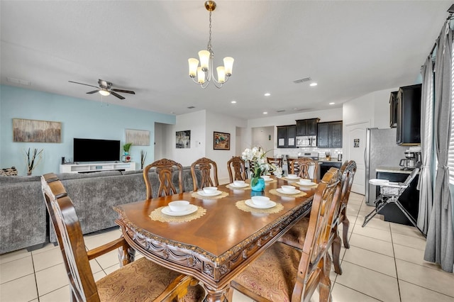 tiled dining area featuring ceiling fan with notable chandelier