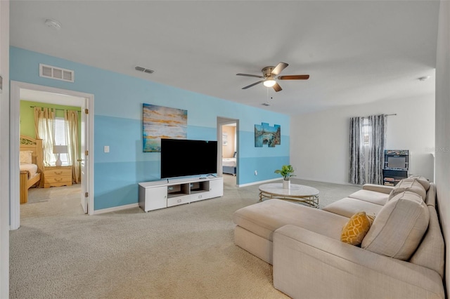 carpeted living room with ceiling fan