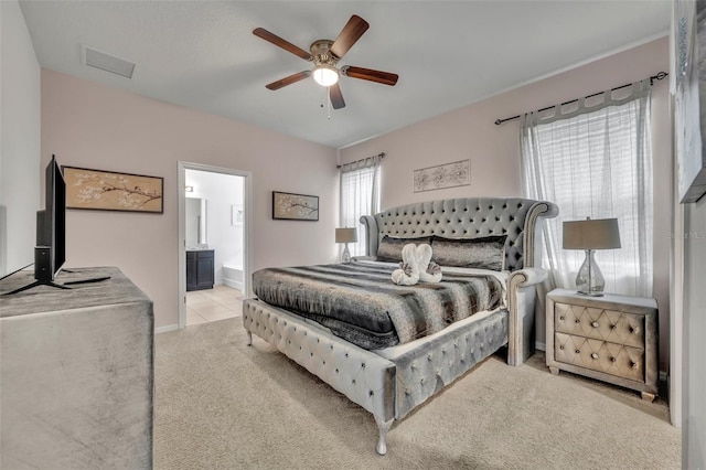 bedroom featuring ceiling fan, ensuite bathroom, and light carpet