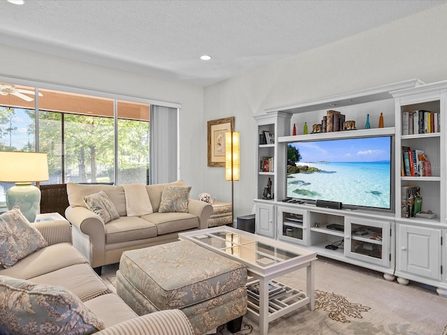 carpeted living room featuring a textured ceiling and ceiling fan