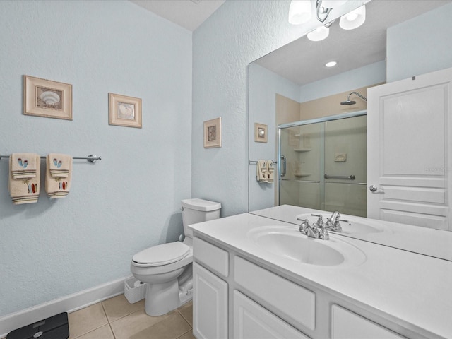 bathroom with tile patterned flooring, vanity, toilet, and a shower with shower door