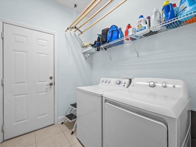 clothes washing area with separate washer and dryer and light tile patterned floors