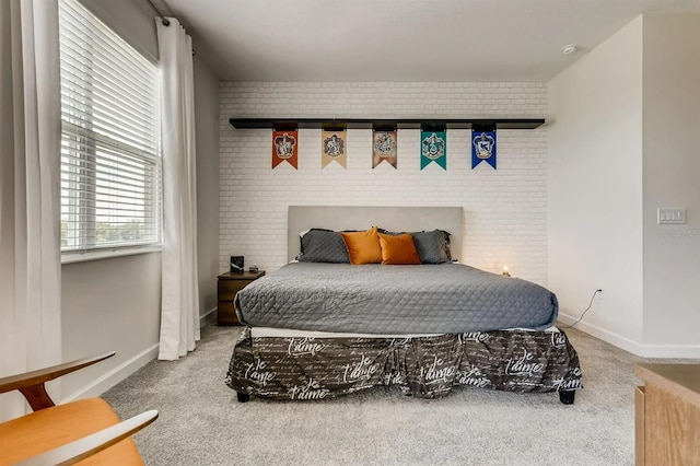 bedroom featuring carpet and brick wall