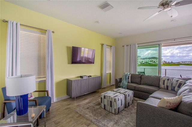 living room with ceiling fan and light wood-type flooring