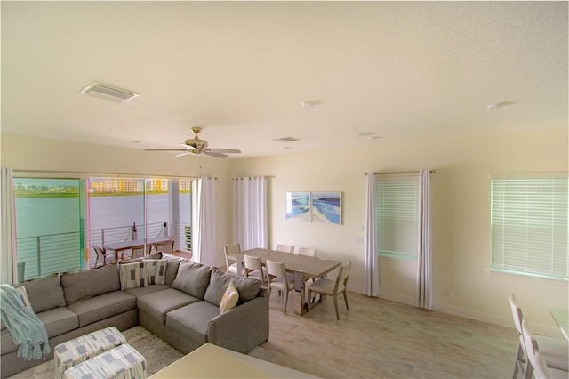 living room with light hardwood / wood-style flooring and ceiling fan