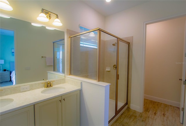 bathroom with vanity, hardwood / wood-style flooring, and a shower with door