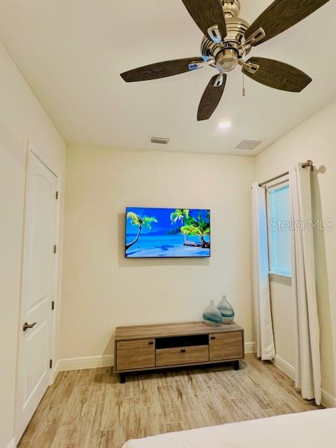 sitting room with light hardwood / wood-style floors and ceiling fan