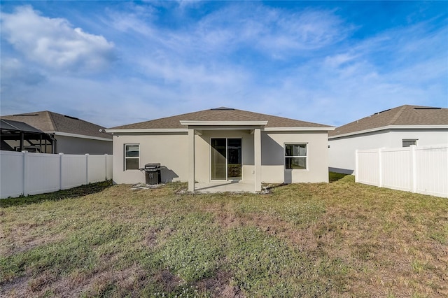 rear view of property featuring a lawn