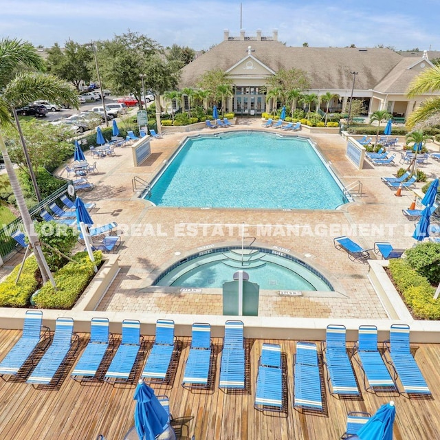 view of pool featuring a hot tub and a patio area