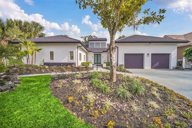 mediterranean / spanish home featuring a front lawn and a garage