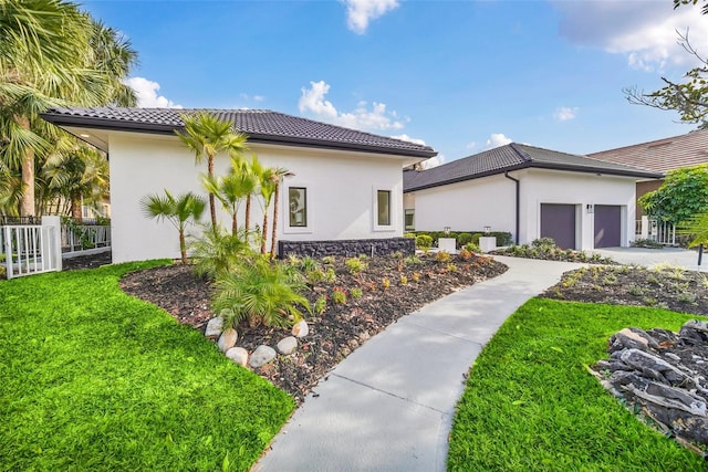 mediterranean / spanish house with a garage and a front yard