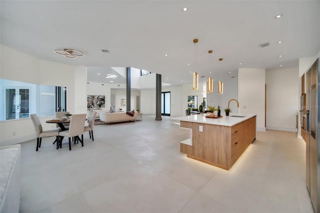 kitchen featuring hanging light fixtures, a large island, and sink