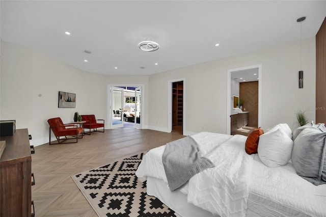 bedroom featuring a closet, connected bathroom, a spacious closet, and light parquet flooring