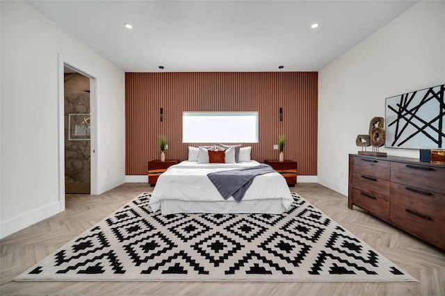 bedroom featuring ensuite bath and light parquet floors