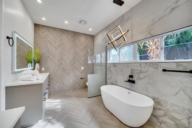 bathroom featuring vanity, tile walls, and separate shower and tub