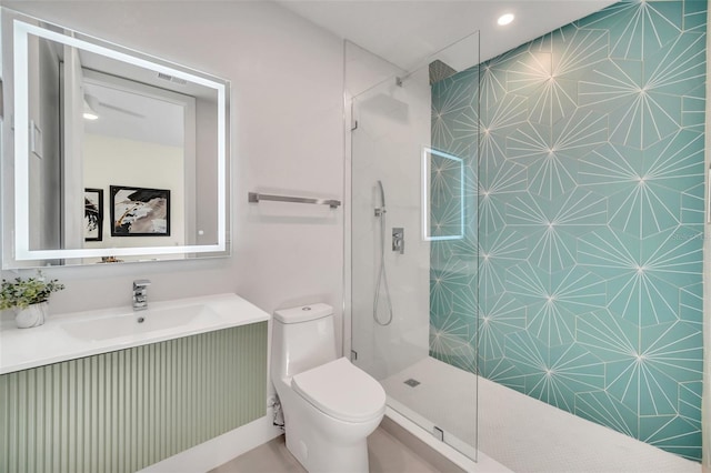 bathroom featuring tiled shower, vanity, and toilet