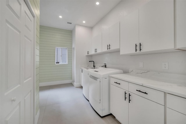 washroom with cabinets and washing machine and clothes dryer